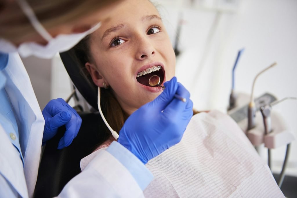 Part of orthodontist examining child's teeth in dentist's office