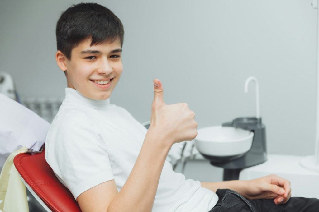 young boy is satisfied with the visit to the dentist. The concept of painless dental treatment.